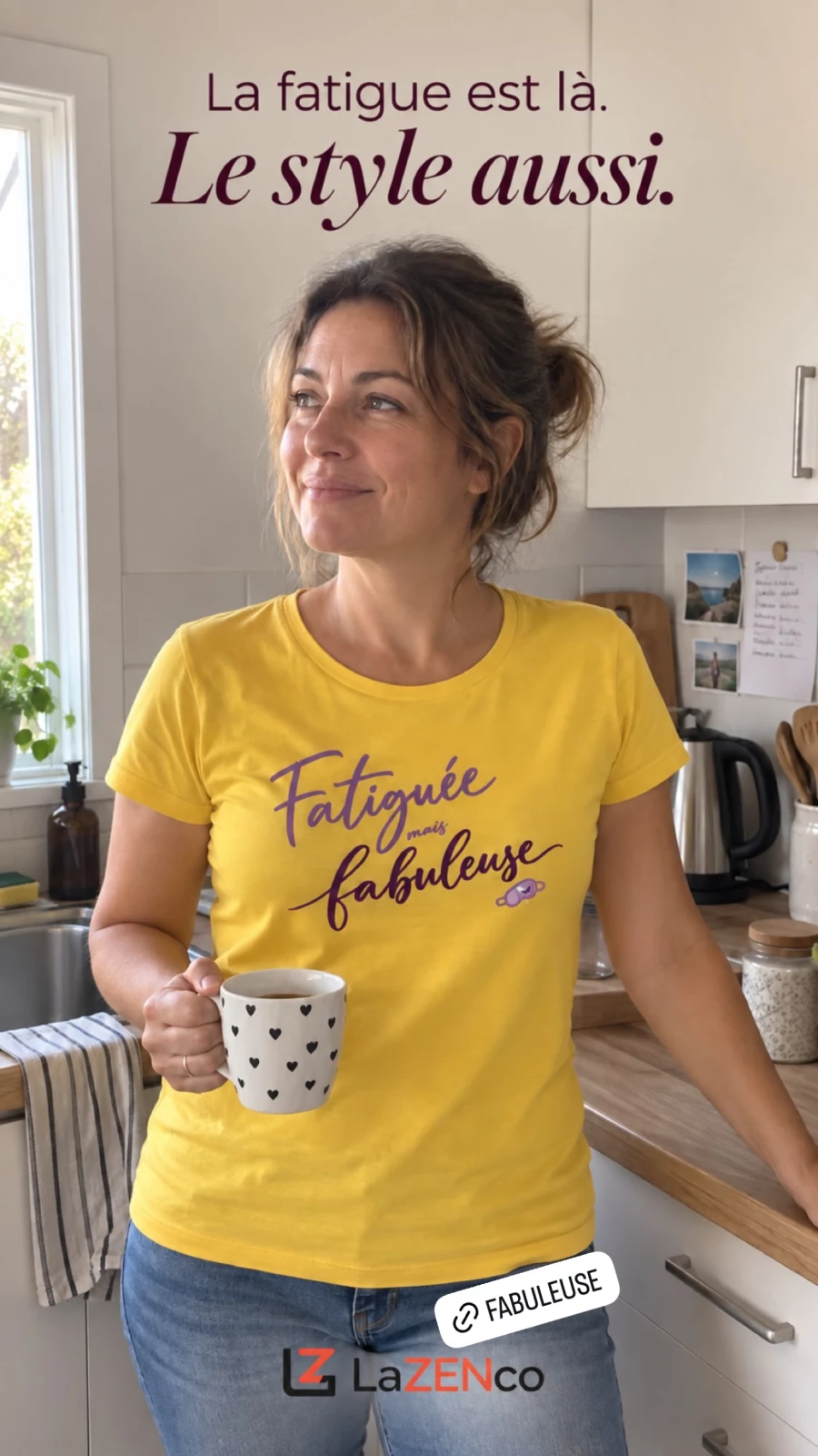 Une femme avec un café dans sa cuisine porte un T-shirt jaune Fatiguée mais fabuleuse.