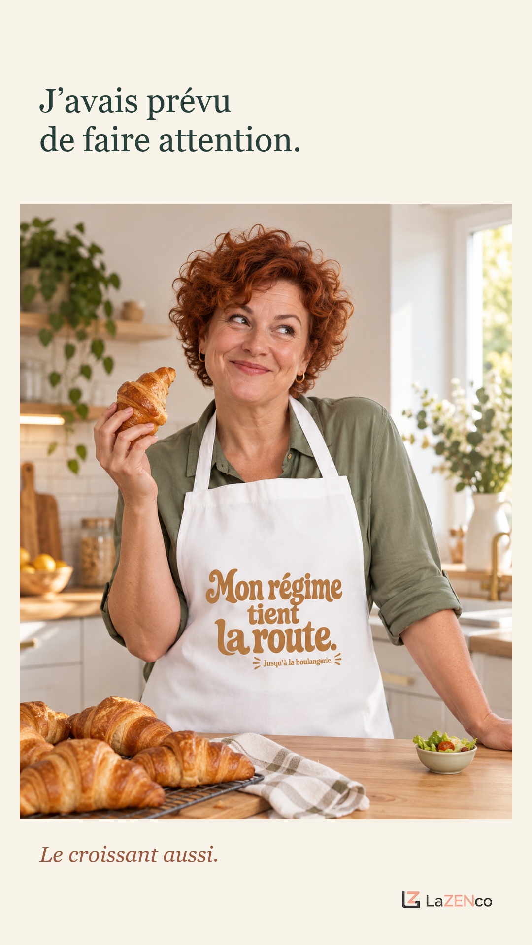 Une femme tient un croissant et porte le tablier Mon régime tient la route. Jusqu’à la boulangerie.